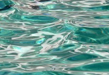 スイミングプールのゆらゆらと揺れながら光を反射する水面を撮影したテクスチャー素材