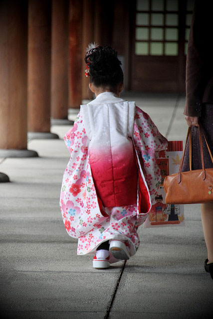 七五三の着物を着て神社を歩く女の子の後ろ姿の写真素材