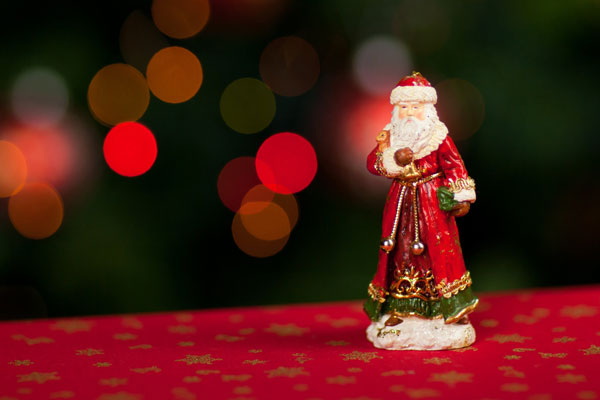 赤と緑のクリスマスカラーに統一されたサンタクロース人形の写真素材