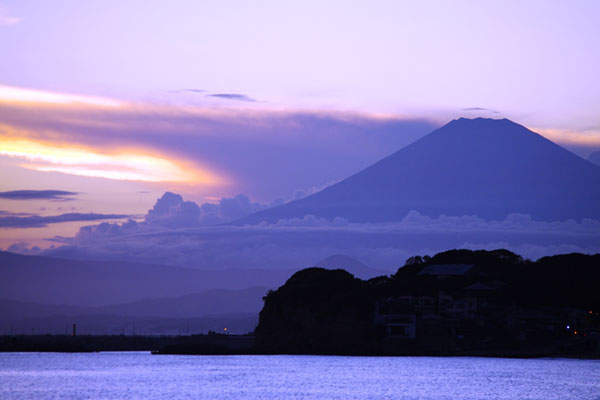 夕焼けでオレンジ色に染まり始めた様子がきれいな富士山の写真素材