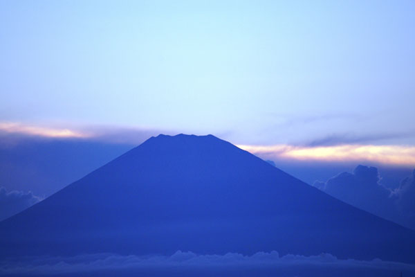 霞がかった空の青に染まった富士山を撮影したきれいな写真