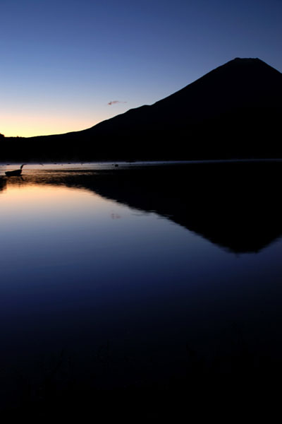 精進湖に映る夜明けの逆さ富士を撮影した写真素材。朝日で浮かび上がったシルエットがきれい。