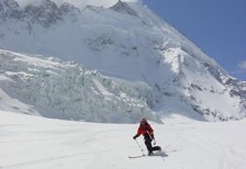スキーをする人物の写真素材。背景のゲレンデと雪山大きく切り取った迫力のある構図