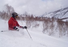 雪しぶきを上げて勢いよくゲレンデを滑るスキーの写真素材