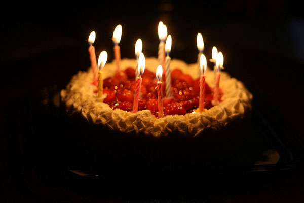 誕生日ケーキを撮影した写真素材。ゆらゆら光るキャンドルが綺麗。