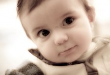 クリっとした目がキュートな赤ちゃんの写真。セピア調のレトロな雰囲気