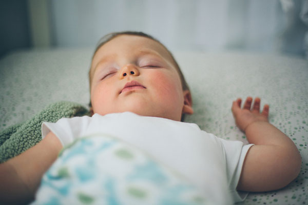 すやすや眠るかわいい赤ちゃんの写真。やわらかいボケ味が綺麗