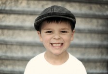 帽子をかぶった男の子の笑顔のポートレート写真。歯を見せて元気に笑う表情がかわいい