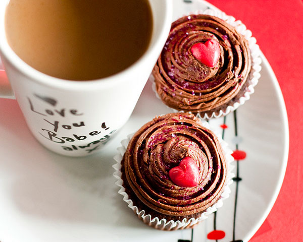 ハート飾りのカップケーキとコーヒーのかわいい写真。バレンタインデーに。