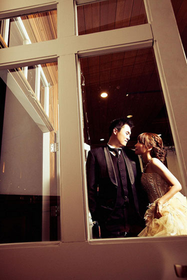 新郎新婦を窓越しに撮影したロマンチックな写真。ブライダル系のデザインに。