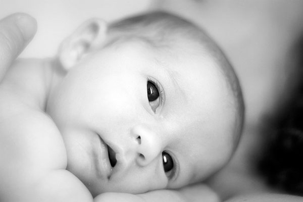 赤ちゃんの顔をアップで撮影した写真。コントラストのクッキリしたモノクロ調。
