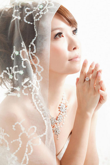ウェディングドレス姿の花嫁の写真。やわらかいベールが繊細で綺麗。