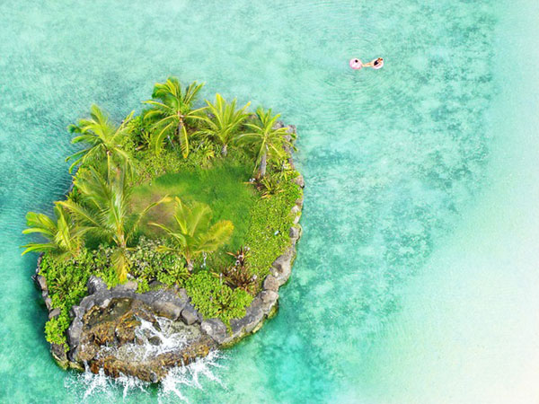 ハワイの小島を上から撮影したフリー写真素材。グリーンのヤシの木と海が綺麗。