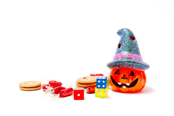 ハロウィンのかぼちゃランタンやお菓子にサイコロなどを並べて撮影した写真