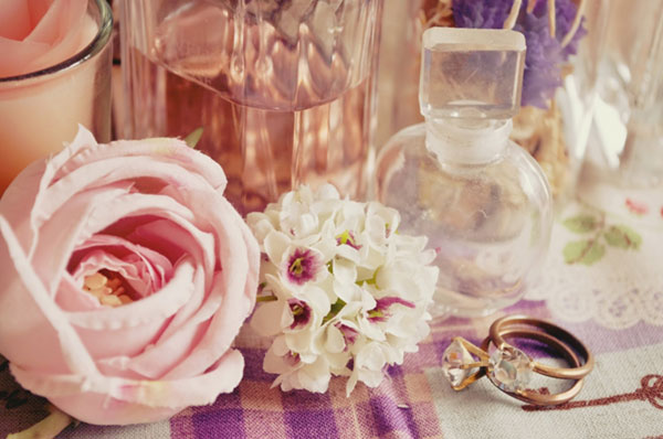 バラの花や指輪に香水などを並べて撮影したガーリーで綺麗な写真