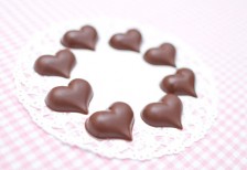 レースの上にサークル状に並べたハート型チョコレートを撮影した写真。バレンタインデーに。