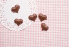 ピンクのストライプ柄の布と小さなハート型のチョコレートを撮影した写真素材