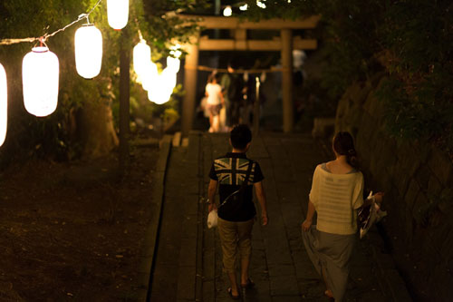 神社のお祭に行く恋人の後ろ姿の写真素材。提灯の柔らかい灯りが綺麗。